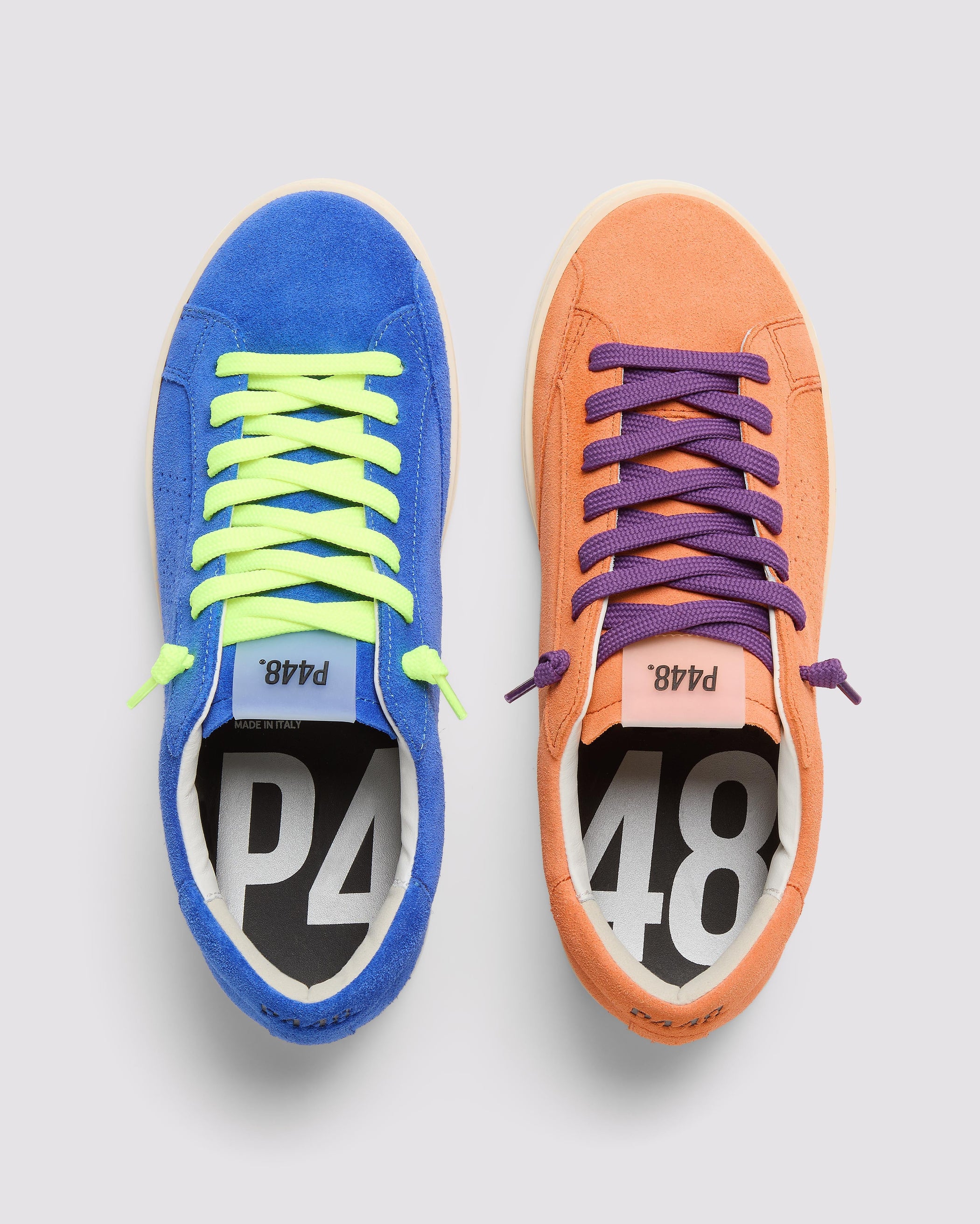 Front angle of the left blue sneaker with yellow laces and right orange sneaker with purple laces