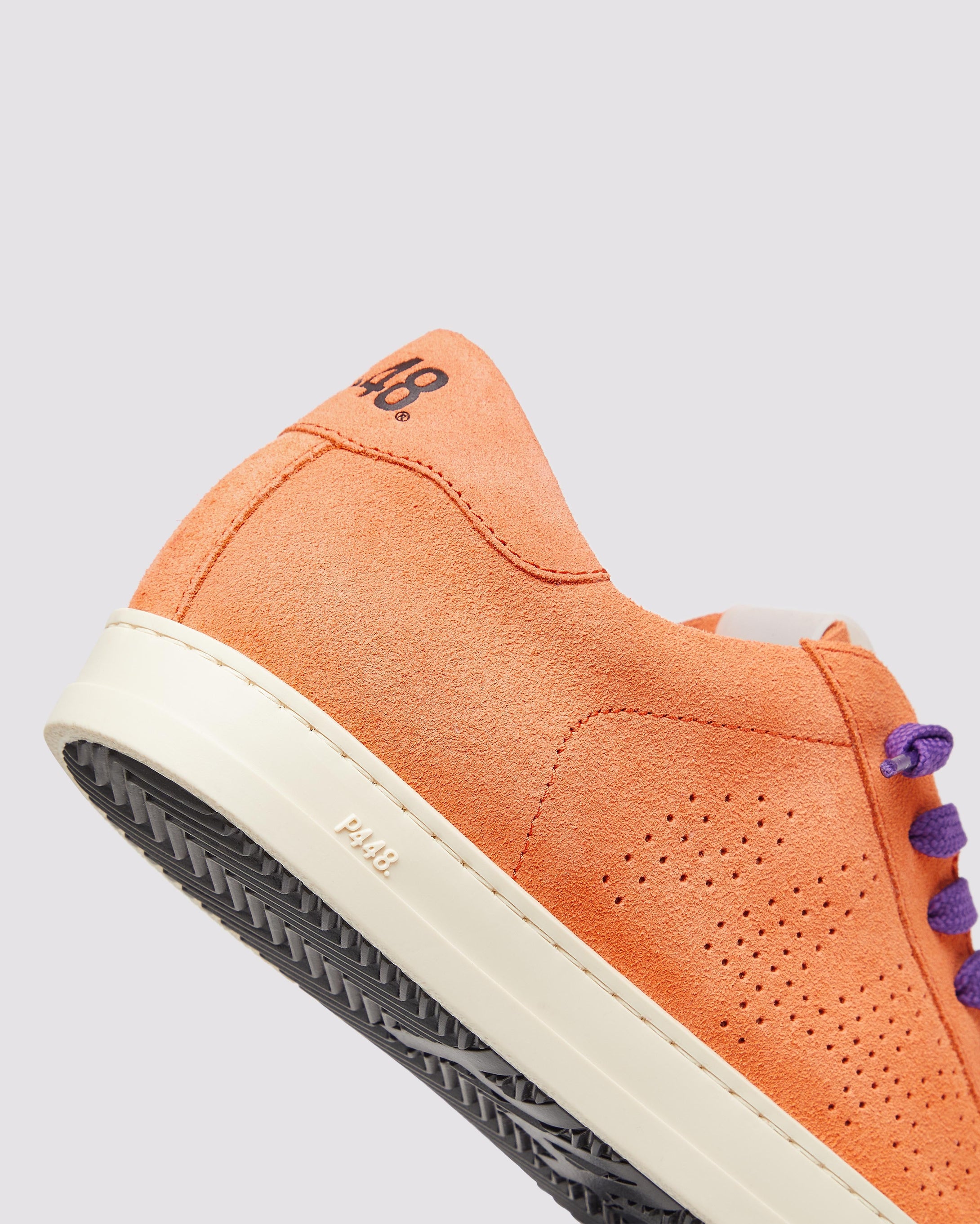 Side angle of the left blue sneaker with yellow laces and right orange sneaker with purple laces
