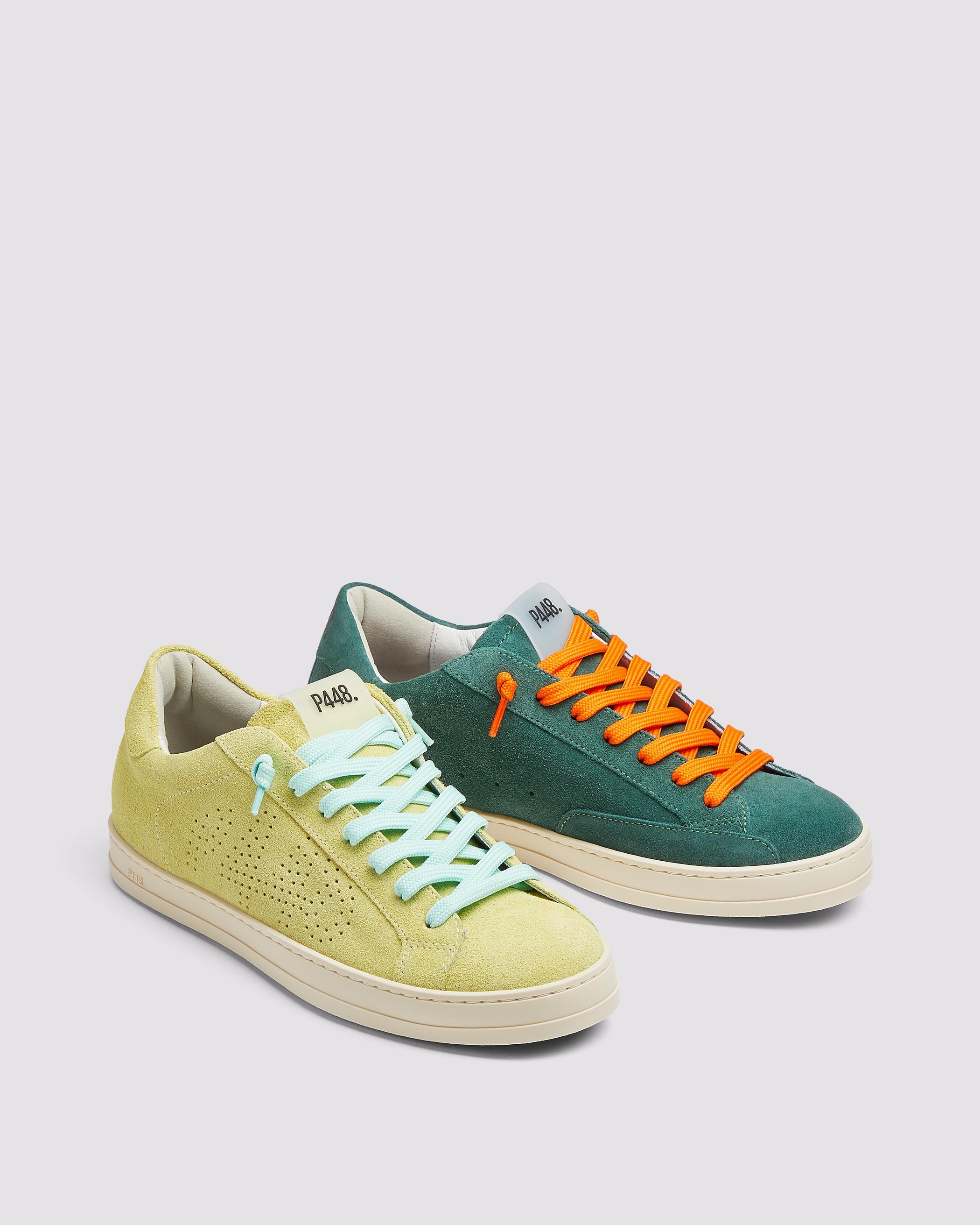 Side angle of the left green sneaker with orange laces and right yellow sneaker with blue laces