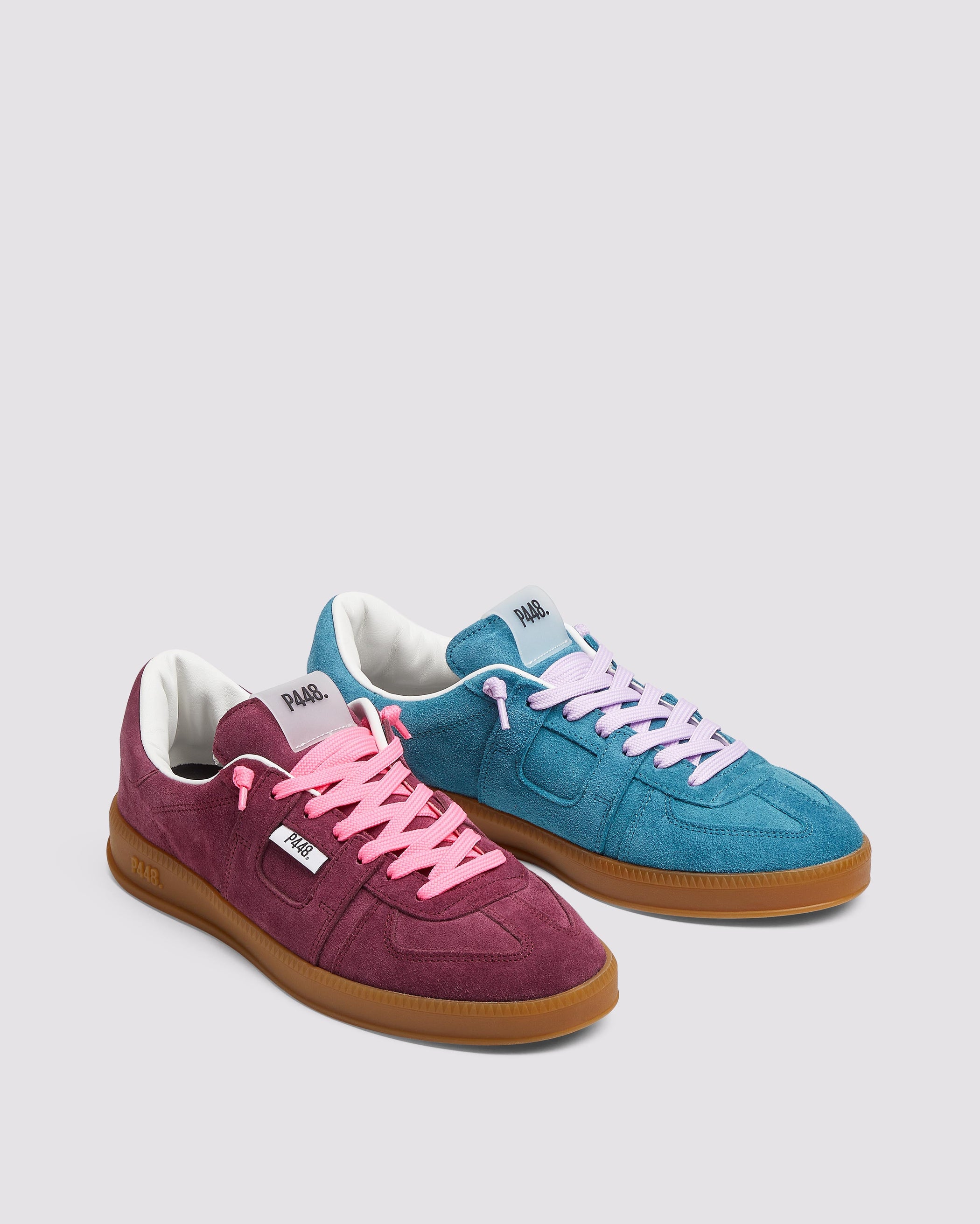 Side angle of the left blue sneaker with purple laces and right burgundy sneaker with pink laces