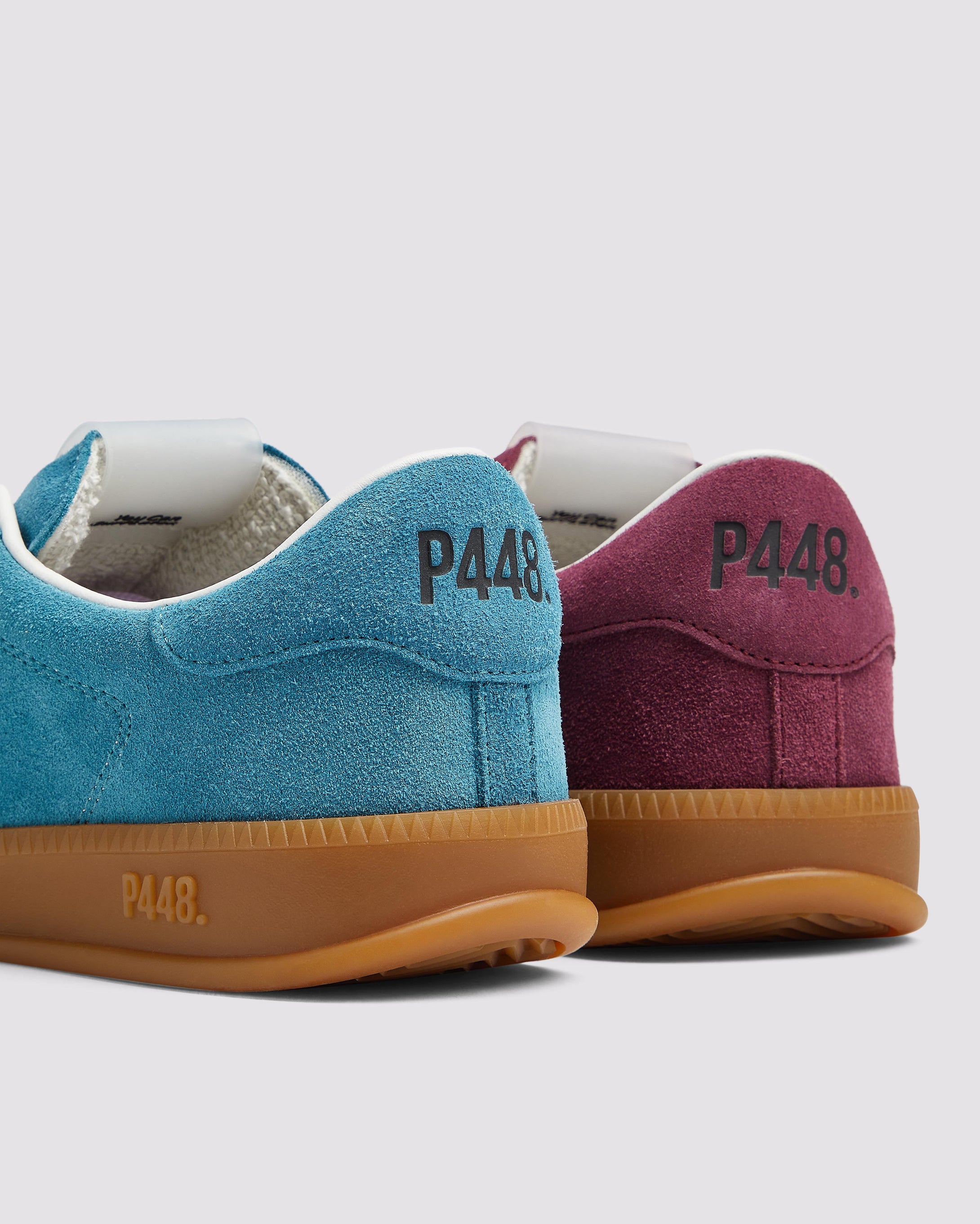 Side angle of the left blue sneaker with purple laces and right burgundy sneaker with pink laces